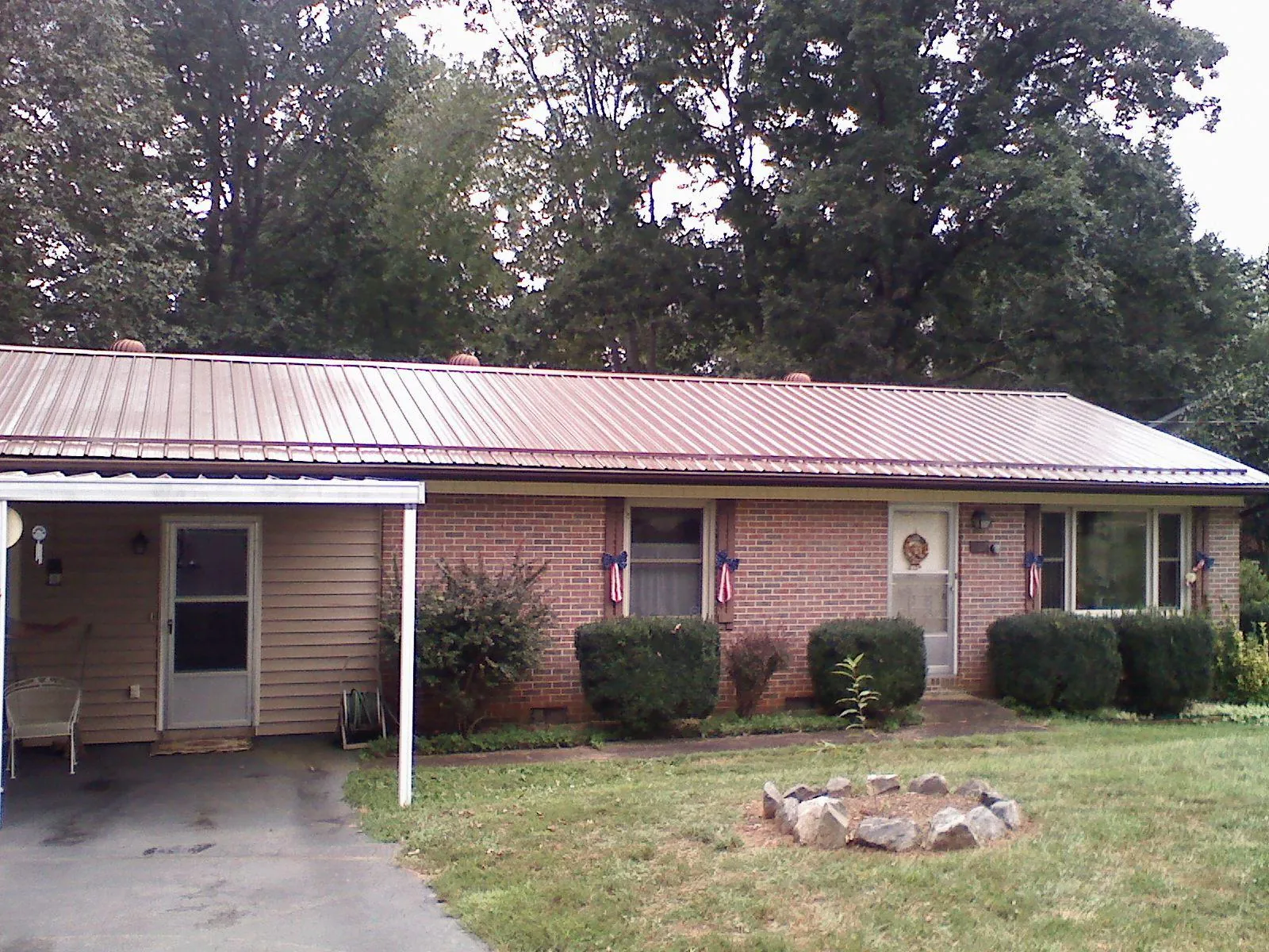 Bronze metal roof and carport on a brick ranch home — Roof Repair work by our crew in Scottville
